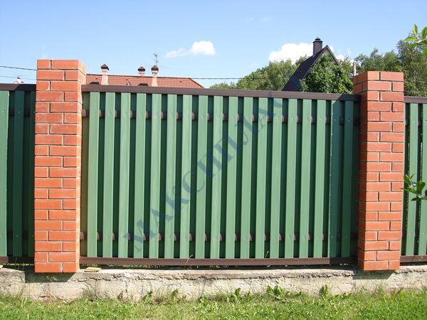 Зеленый забор из штакетника с кирпичными столбами